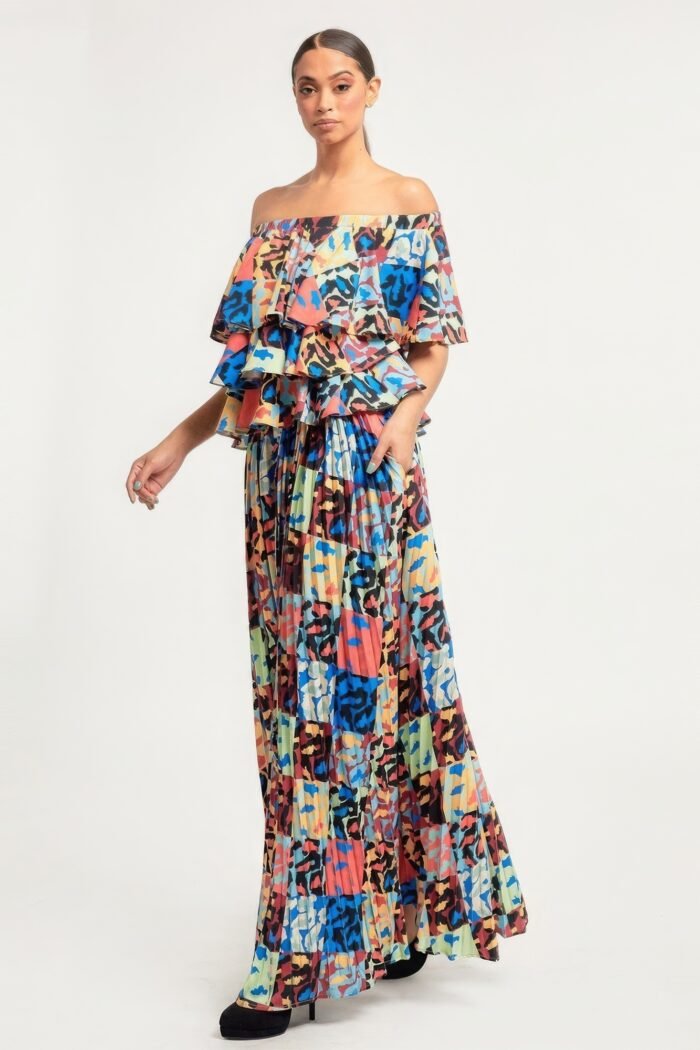 Printed ruffle top and pleated skirt set in orange with adjustable styling options and functional pockets.