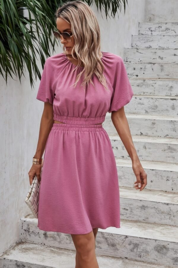 Woman wearing pink two piece skirt set – crop top and high-waisted mini skirt, solid color, elastic waistband