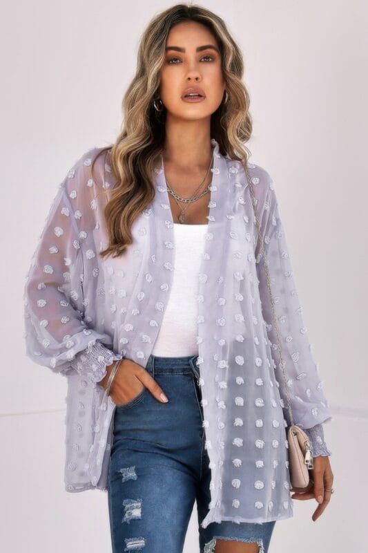 Woman wearing polka dot open front top – long sleeve, lightweight casual blouse with front tie or button design