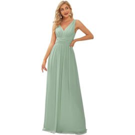 A woman modeling a sage green floor-length chiffon evening gown with a deep V-neckline and a ruched, pleated empire waistband.